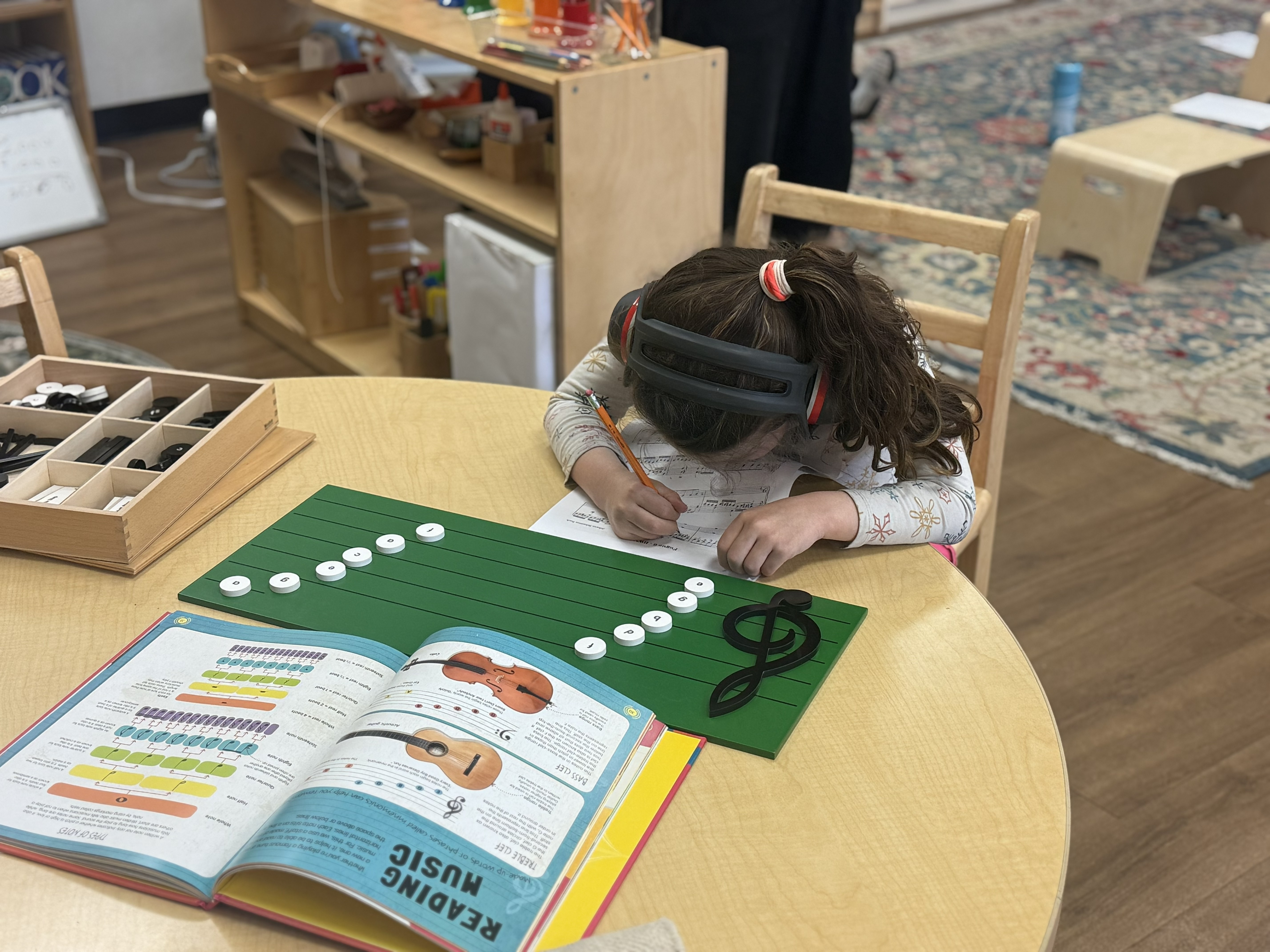 Student studying music with treble clef material and reading music book